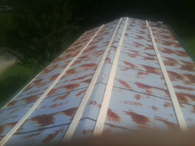 Rusted metal roof panels with new wood purlins before replacement — Storm Damage Roof Repair in New Bern by Roofing Brothers
