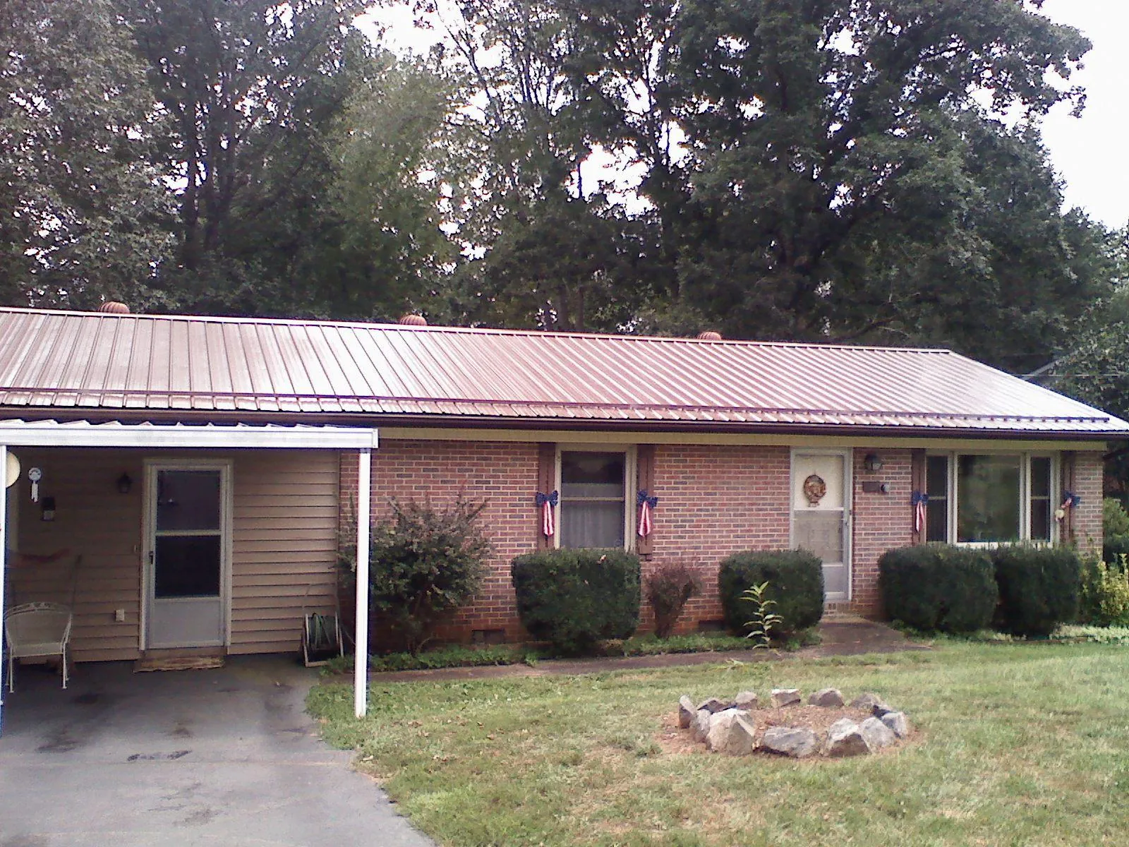 Bronze metal roof and carport on a brick ranch home — Roof Repair work by our crew in New Bern