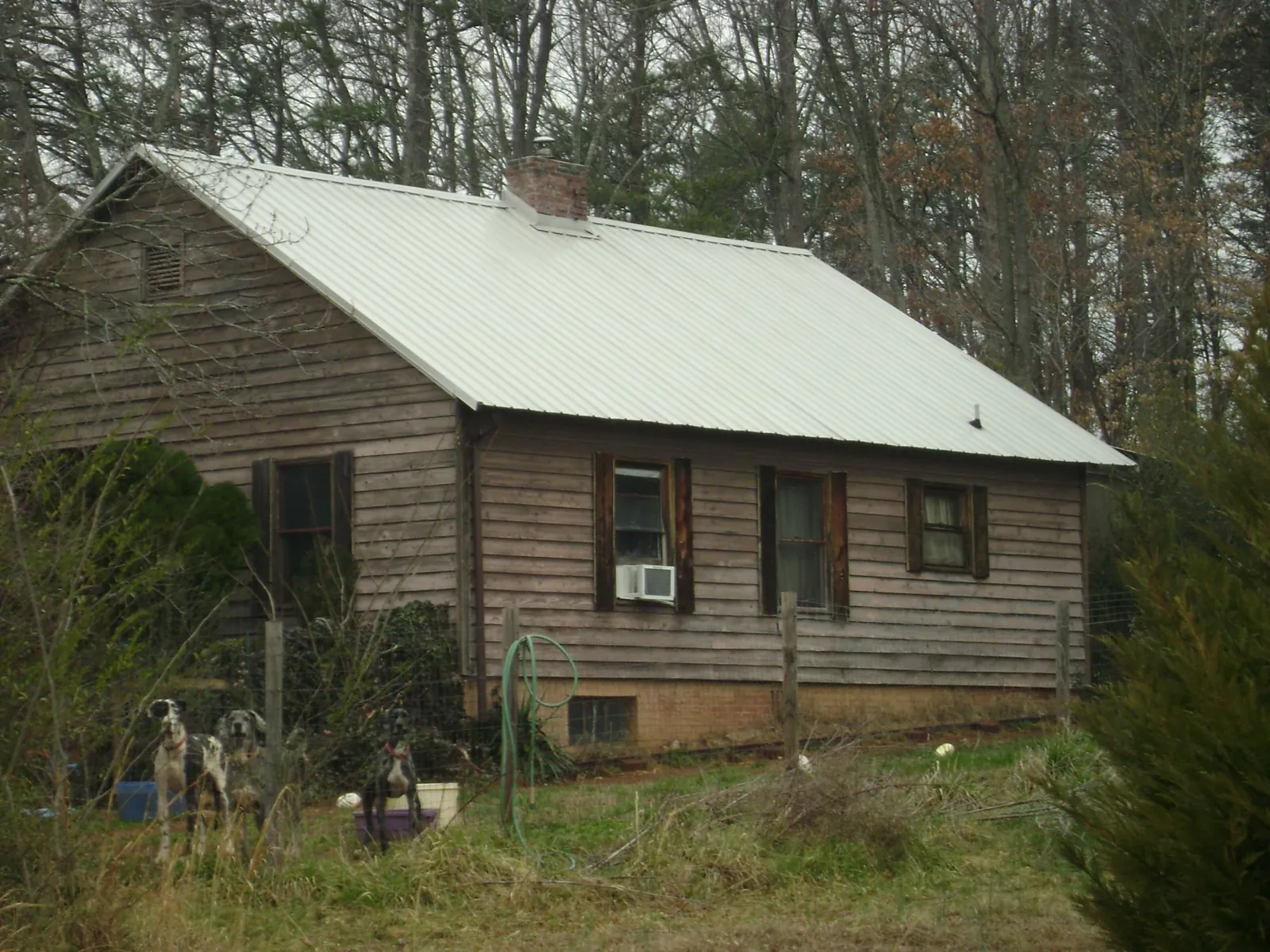 White metal roof on an old wood sided farmhouse, from a Metal Roof Installation job in New Bern